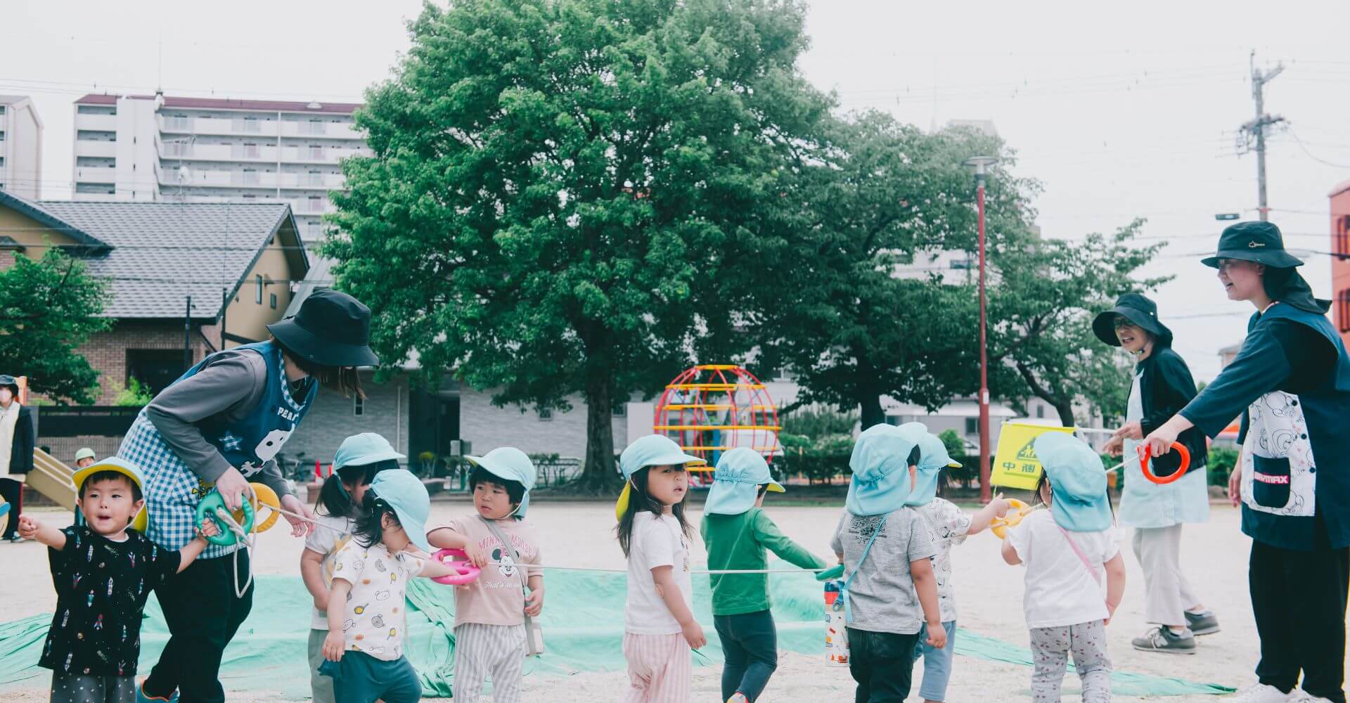 園庭で遊ぶ園児と先生たち